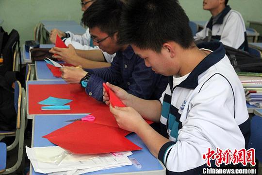 资料图。兰州兰炼一中学生正在学习甘肃庆阳剪纸。　刘玉桃 摄