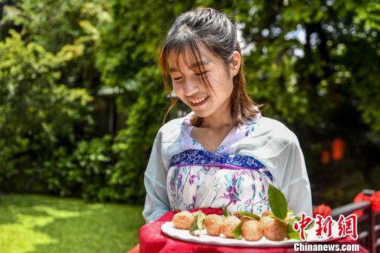 图为身着汉朝服饰的服务员传送“红云宴”菜品。　陈骥旻 摄