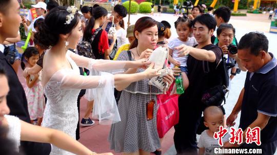 一些带着小孩的爸爸妈妈们也来“蹭”领狗粮，希望能沾沾新人们的喜气。　许泽汉 摄